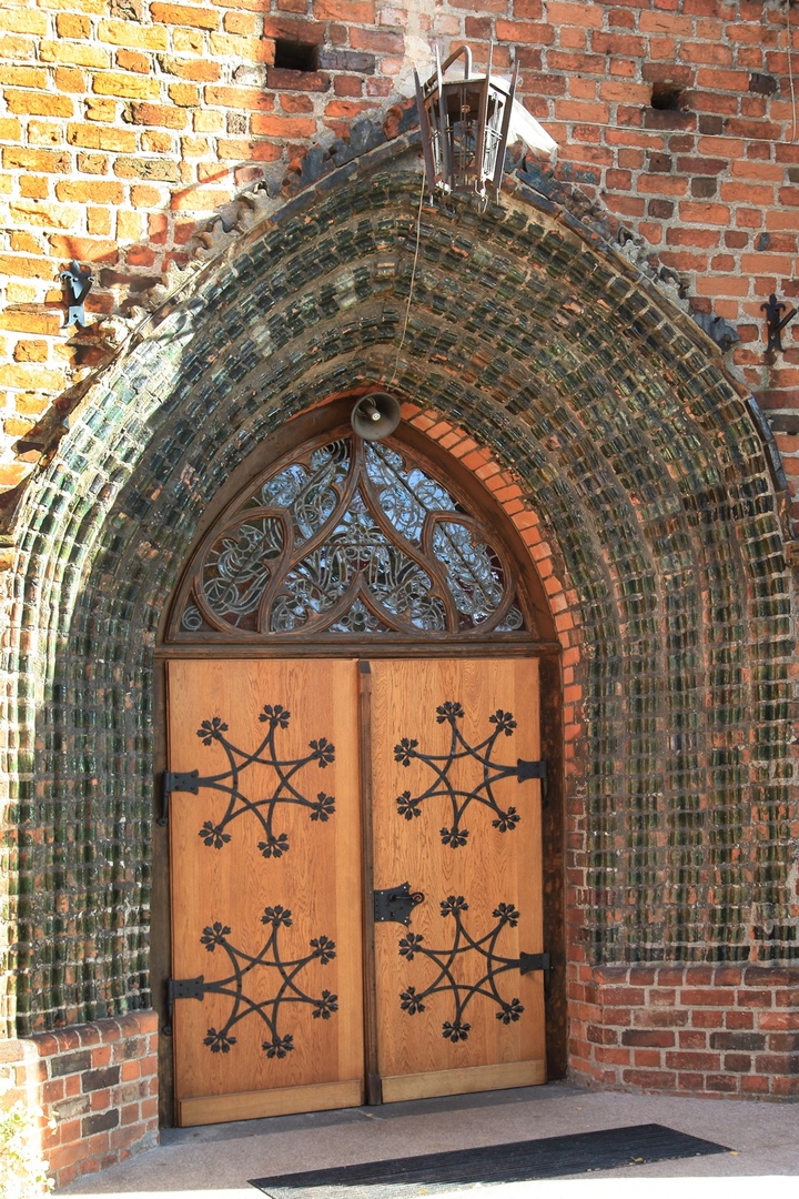 portal z drewnianymi drzwiami wejściowymi